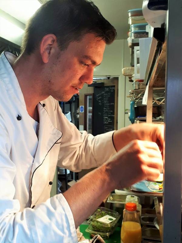 The chef working at the pass in the kitchen.