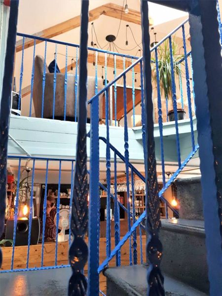 A staircase with blue railings and warm lights.